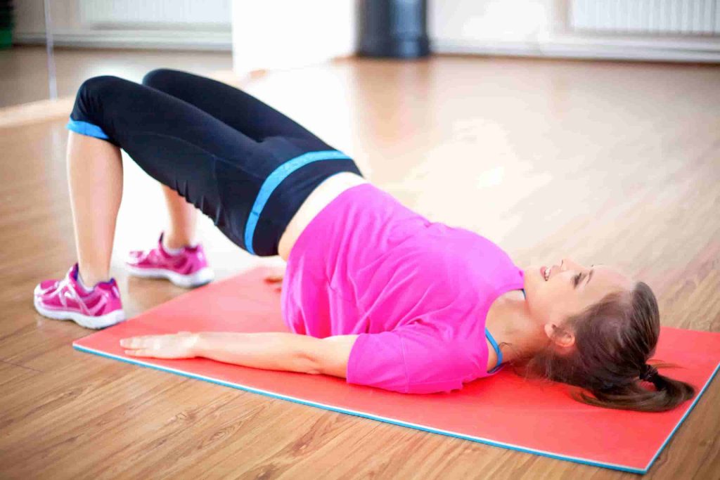 happy-woman-doing-pelvic-muscle-exercise-mat